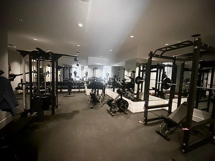Custom large home gym build in Abbotsford, BC — dual squat racks, cable machine, dumbbell wall, and full mirror wall