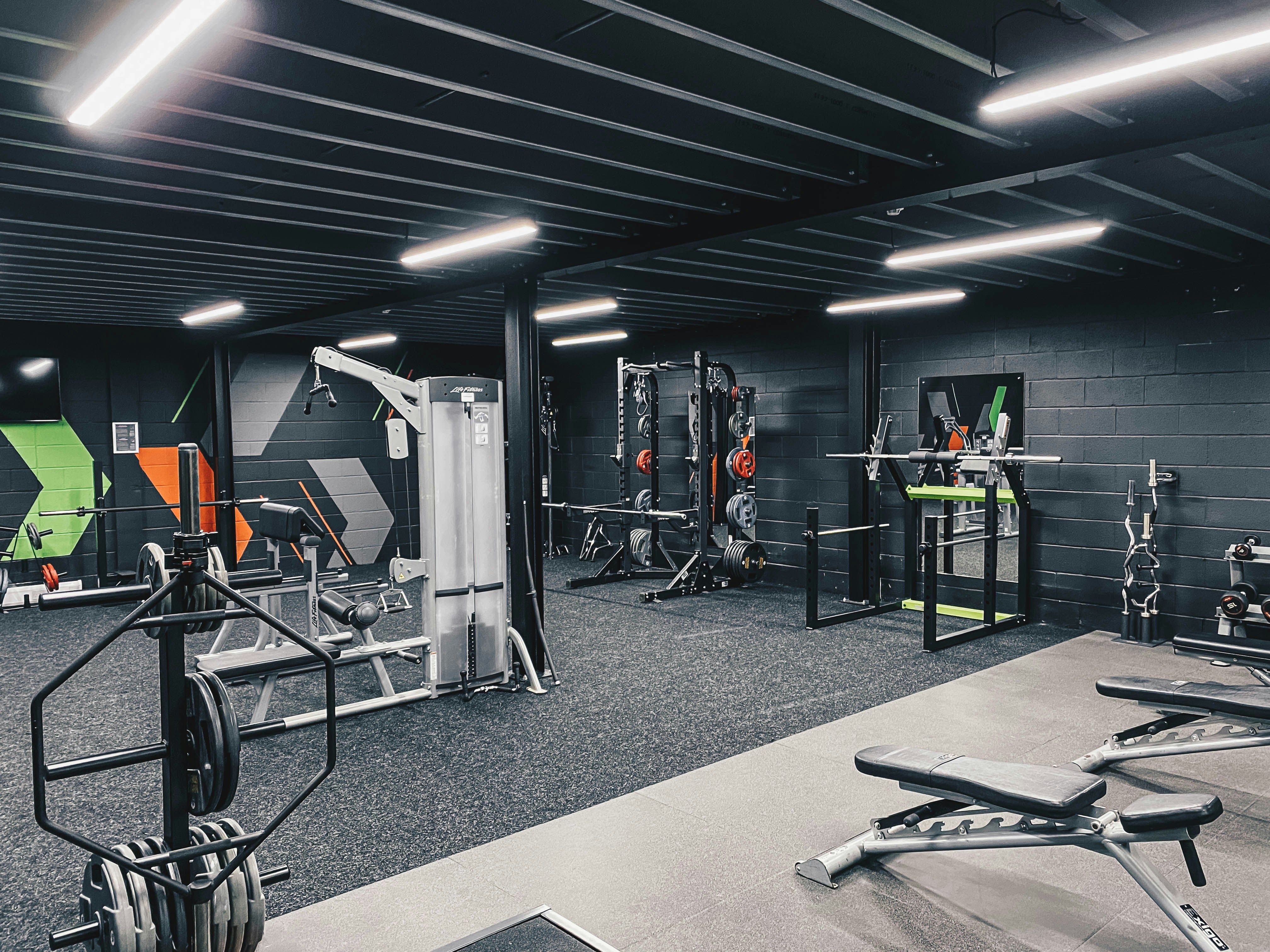 Custom home gym layout showing squat rack, cable machines, adjustable benches, and rubber flooring — the kind of build that comes out of our 3D design stage.